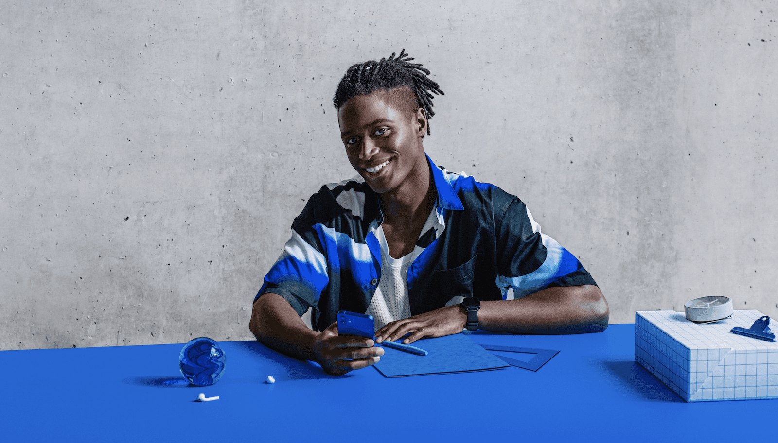 CLARK product photography — a person at a blue desk set, editorial lifestyle scene